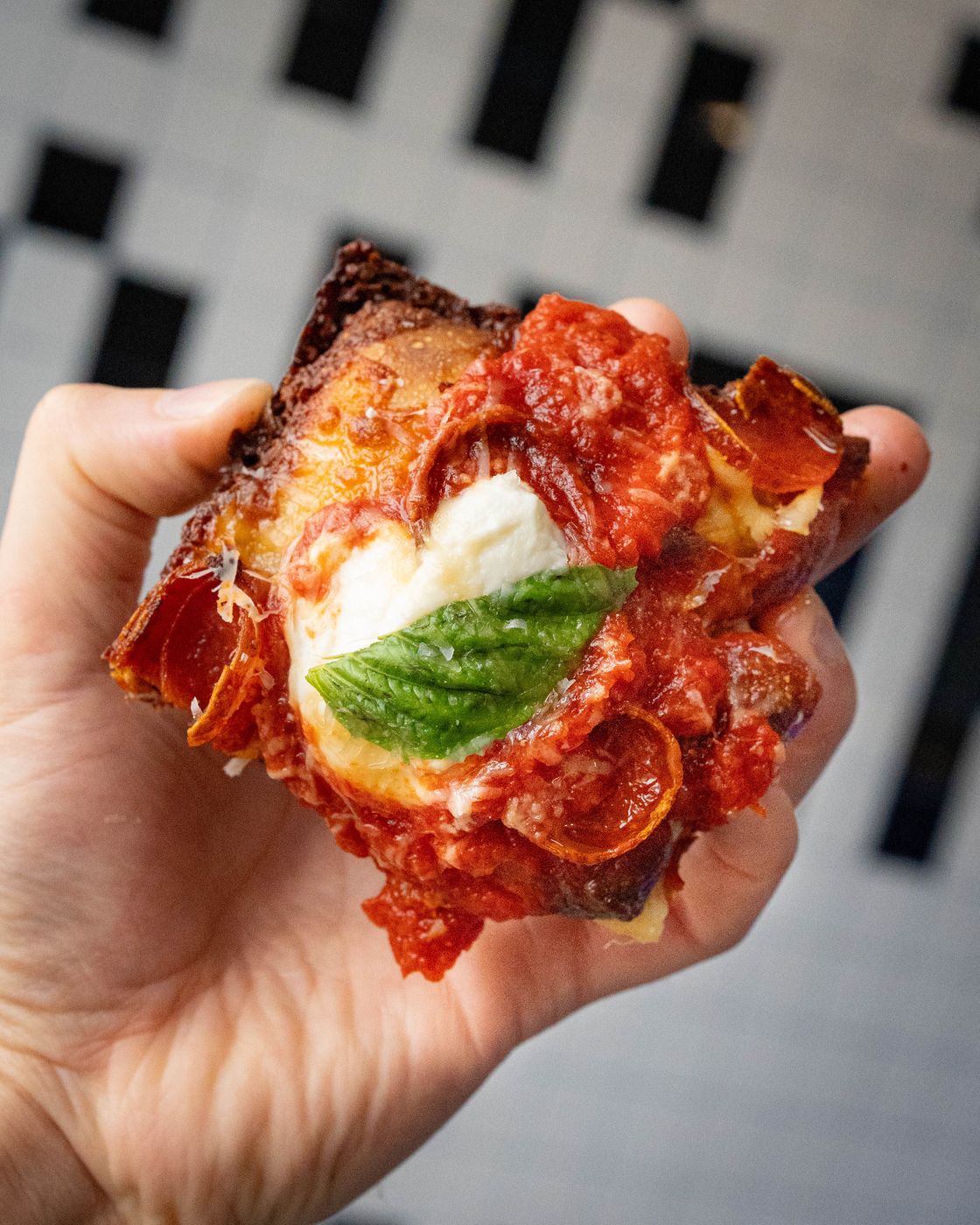 Pepperoni cup square, sauce and basil on top